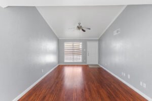 Spacious living rooms with wood floors available at Falls of Dairy Ashford Apartments.
